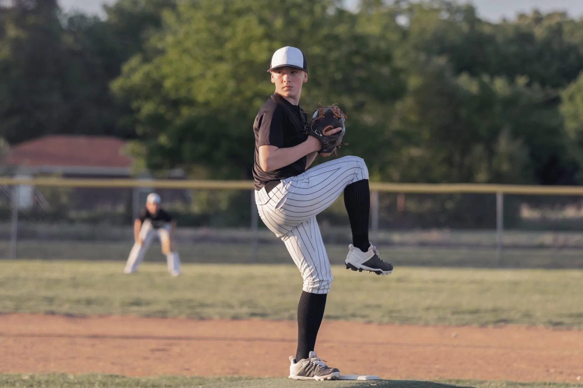 Right-handed pitcher winds up to throw pitch to batter