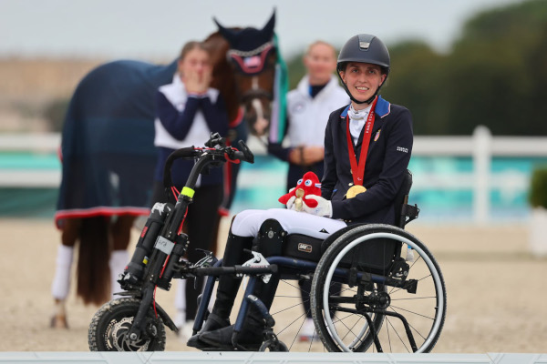 Woman in wheelchair with Paralympic gold medal around neck