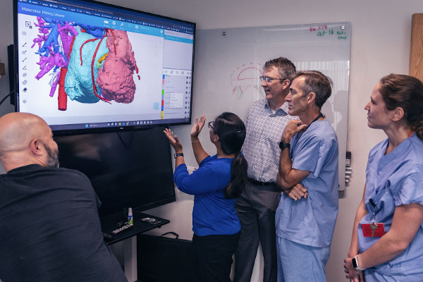 Clinicians gather around screen to review images of the heart